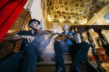 Musicians performing with guitar and vionin.