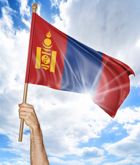 Person's hand holding the Mongolian national flag and waving it in the sky, 3D rendering