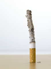 cigarette with long ash on wood table backgroud