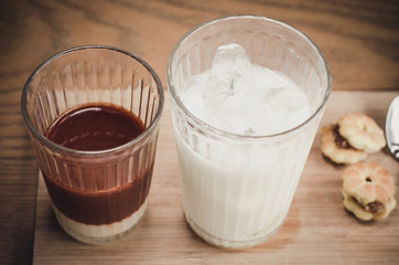 Thai Tea comes in a milk glass of cold , and syrup on a wooden t