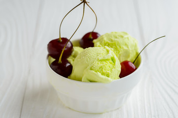 Pictachio ice cream in white bowl with cherry