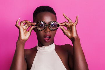 Beautiful and shocked african girl portrait wearing funny glasses - obrazy, fototapety, plakaty