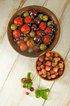 Image of different berries on a wooden board close up