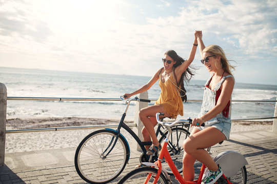 Female Friends Enjoying Cycling On A Summer Day