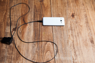 top view of white smartphone and adapter charger