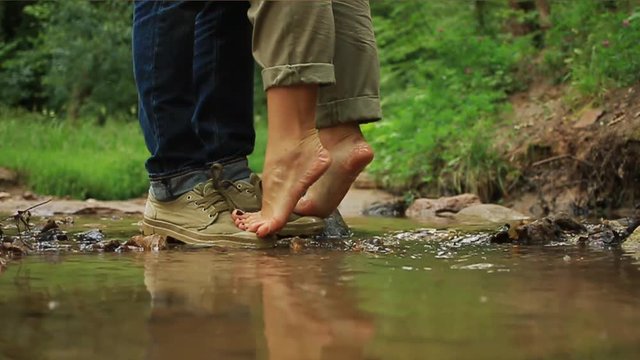 A young loving couple hugging and kissing. Two lovers, man and woman barefoot near the water.