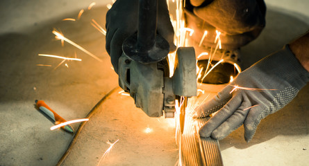 worker cutting metallic profile on floor