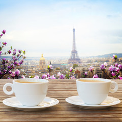 two cups of coffee in Paris cafe with view of parisian roffs and Eiffel Tower