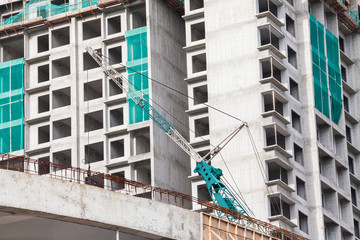 The technology or art of high rise apartment construction using crane, lift, metal beam, brick, metal ladder and concrete in construction site.