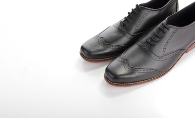 Shiny black leather shoes on white copyspace