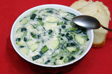A bowl with a cold summer soup with cucumbers