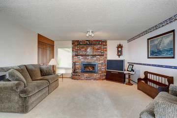 Cozy American living room with gray sofa and brick fireplace
