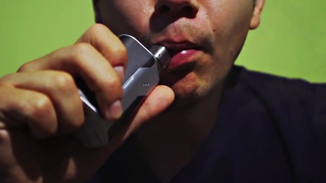 Man Exhaling smoke from a vaporizer shot in slow motion