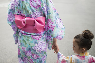 浴衣を着て手をつなぐ親子