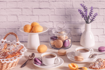 Breakfast with various macaroons, croissants and hot chocolate.