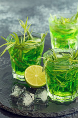 Green cocktail with lime, soda, crushed ice and tarragon leaves.