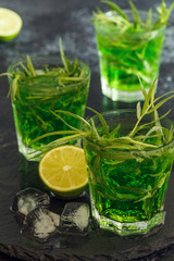 Green cocktail with lime, soda, crushed ice and tarragon leaves.