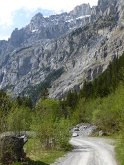 Road through the remote Gasterntal valley, Switzerland with the rock face of the mountains rising...