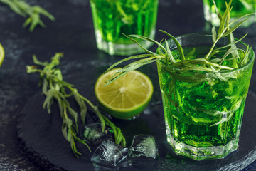 Green cocktail with lime, soda, crushed ice and tarragon leaves.