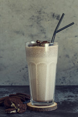 Milkshake with cookies in a tall glass.