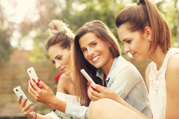 Happy group of friends with smartphones