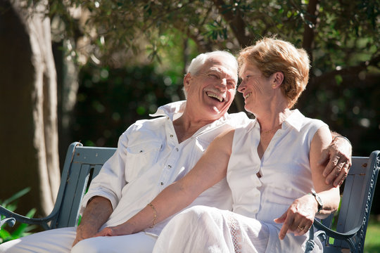 couple de séniors heureux sur un banc de jardin