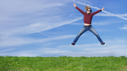 Happy man jumping for joy on grass, with space for text