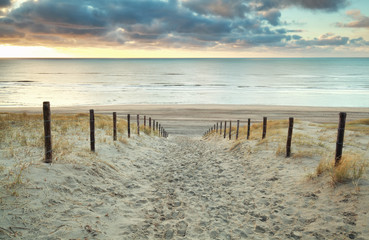 chemin de sable vers la mer du Nord au coucher du soleil