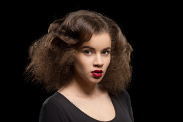 Portrait of beautiful lady with red lips over black background. Pretty model woman with modern hairstyle in studio.