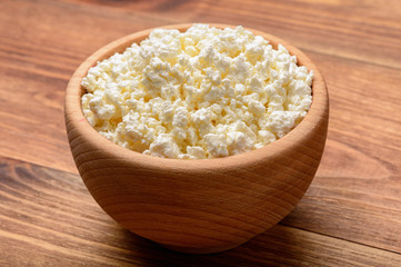 Cottage cheese in wooden bowl. Close-up.
