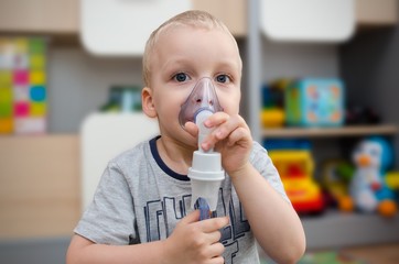 Child making inhalation with mask on his face.