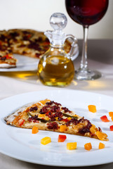 Italian gourmet pizza accompanied by red wine and spices