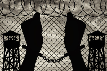 Silhouette of human hands in handcuffs