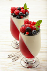 Delicious dessert - panna cotta with berry jelly and berries.
