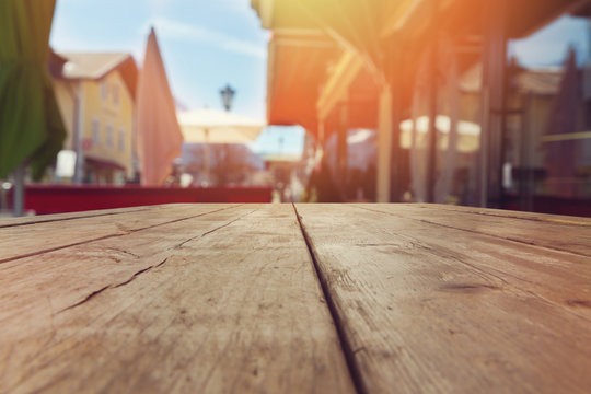 Empty Wooden Rustic Table Over Outdoor Blurred Restaurant Background