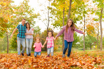 Naklejka premium Parents walk in the park with little girls