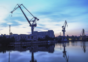 Silhouette of portal cranes in harbor, shot during sunset