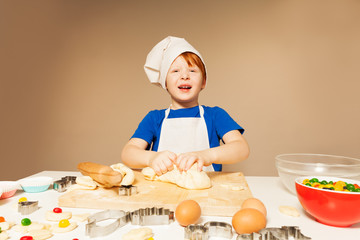 Cute baker kneading dough for candy filled cookies