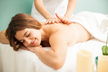 Obraz na płótnie Canvas Happy woman getting a massage at the spa