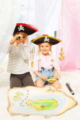 Two cute pirates looking through a toy spyglass