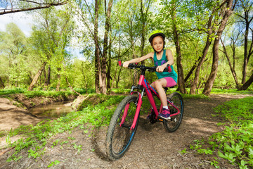 Fototapeta na wymiar Young girl cycling mountain bike on forest trail