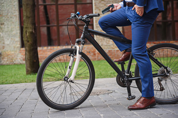 Man in suit cycling on street