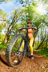 Woman riding a mountain bike on forest trail