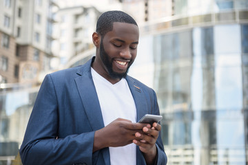 African businessman messaging in big city