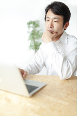 デスクワークするミドル男性・白バック