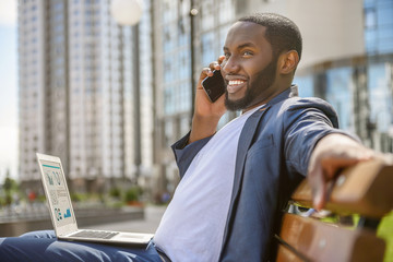 Joyful African businessman using modern technology