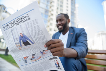 Cheerful African businessman relaxing in city