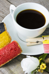 Obraz na płótnie Canvas cookies with red black and yellow glaze as the Belgian flag colors. cup of coffee and a homemade flag of Belgium, decorative patriotic breakfast and lunch National Day. Selective focus photo image