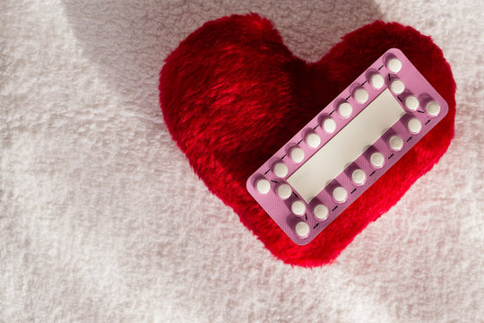 Oral contraceptive pills on red heart