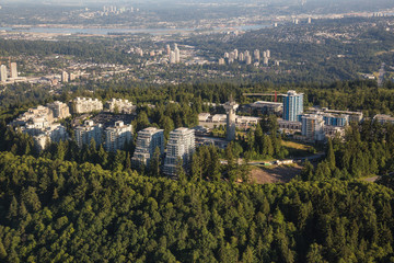 Obraz premium Aerial view of residential buildings on top of SFU (Burnaby Mountain). Picture taken from an airplane on a hazy sunny day in Vancouver, British Columbia, Canada.